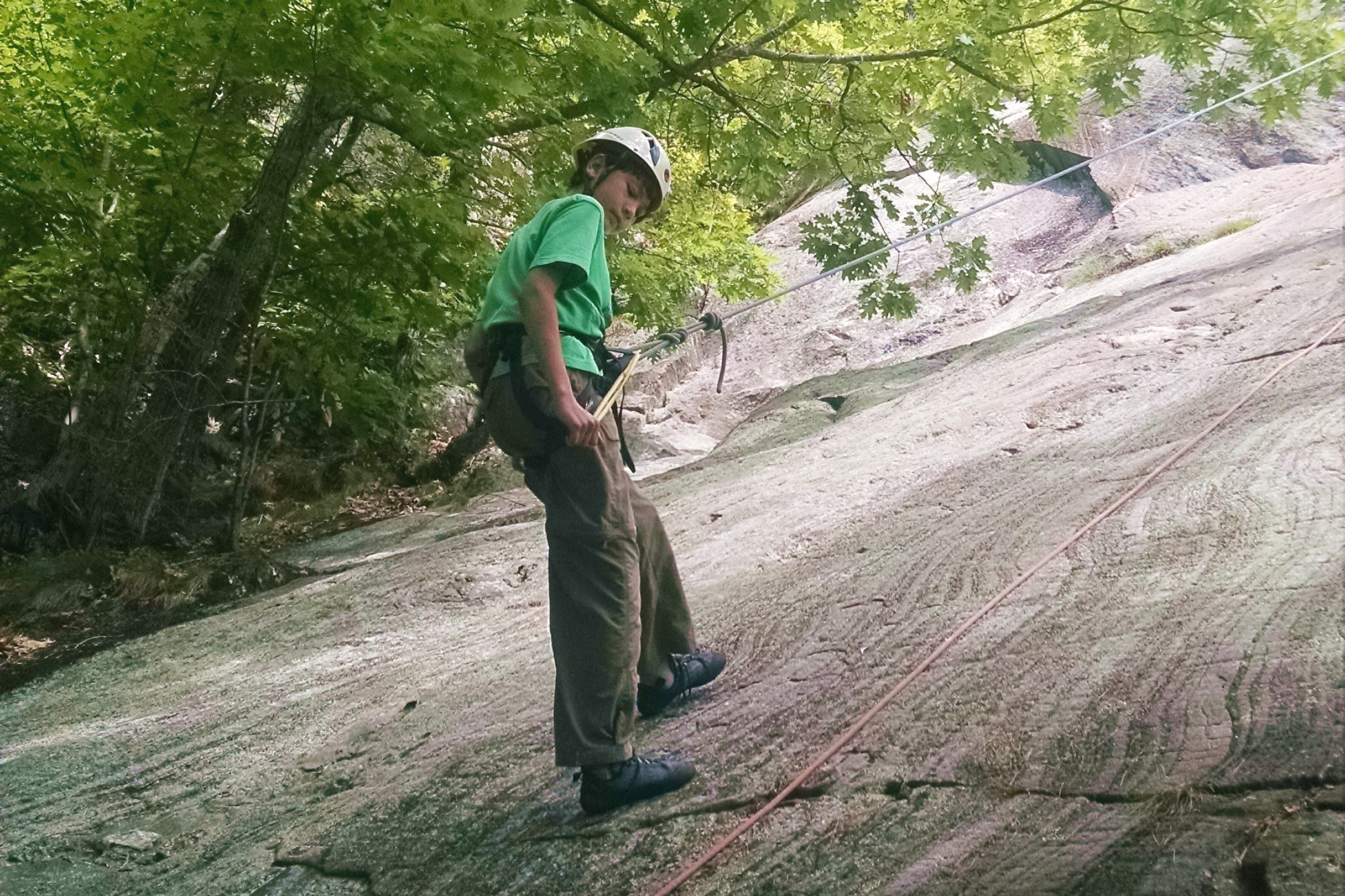 A teen rappels down a cliff face on a Teen Adventure Trip