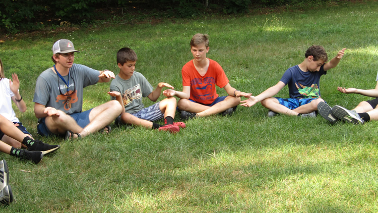 Campers play icebreaker games at the sports field.