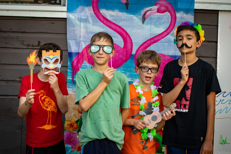 Campers pose with props for a photo booth