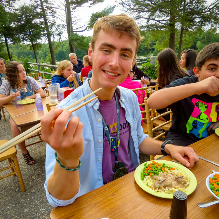 Dustin Ledgard enjoying an outdoor lunch at Wildwood with chopsticks