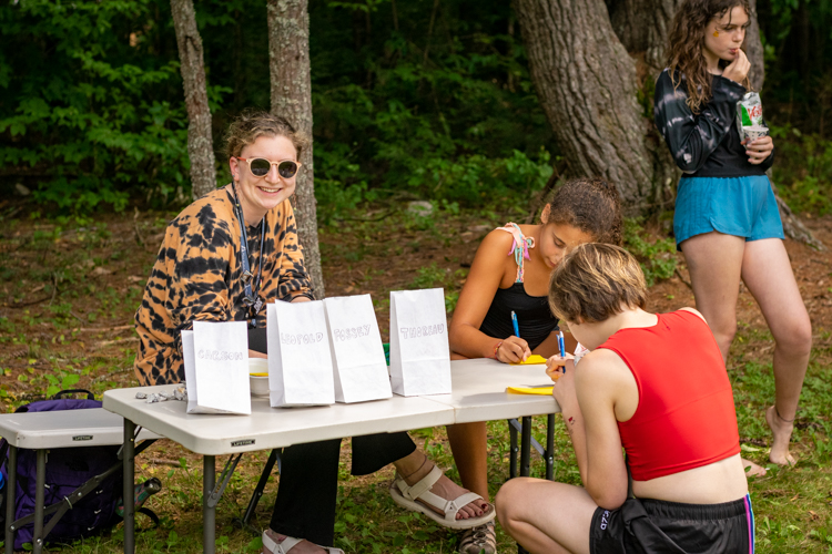 Chickadee helping campers write "Warm Fuzzies" with positive messages for their fellow campers and staff