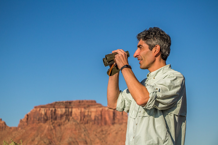 Flavio Sutti holding binoculars at Arches National Park in Utah