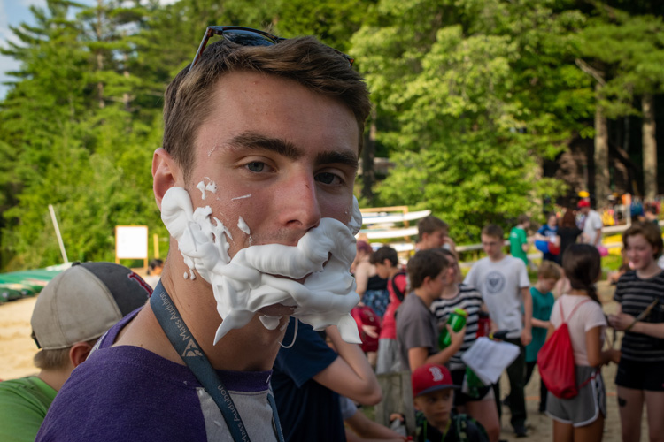 Dustin Ledgard leading a silly Camp Olympics activity involving shaving cream